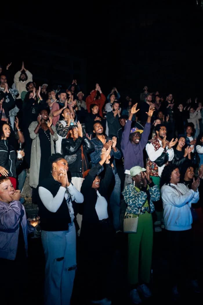 A crowd applauding at a come.unity gathering